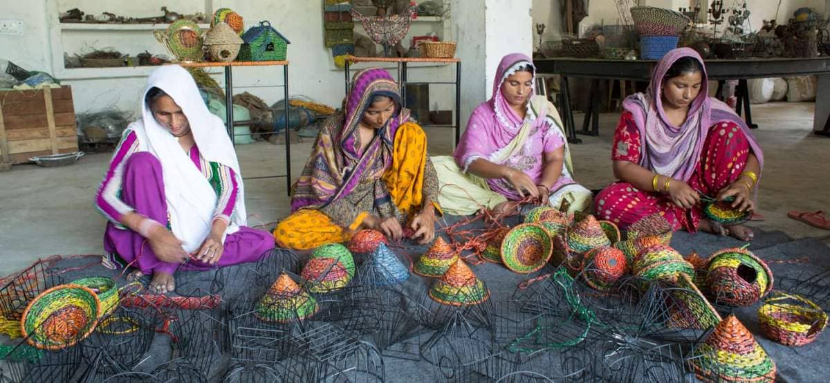 A group of women are manufacturing baskets in a workshop.