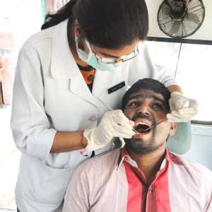 A man undergoes a dental check-up at a health camp.