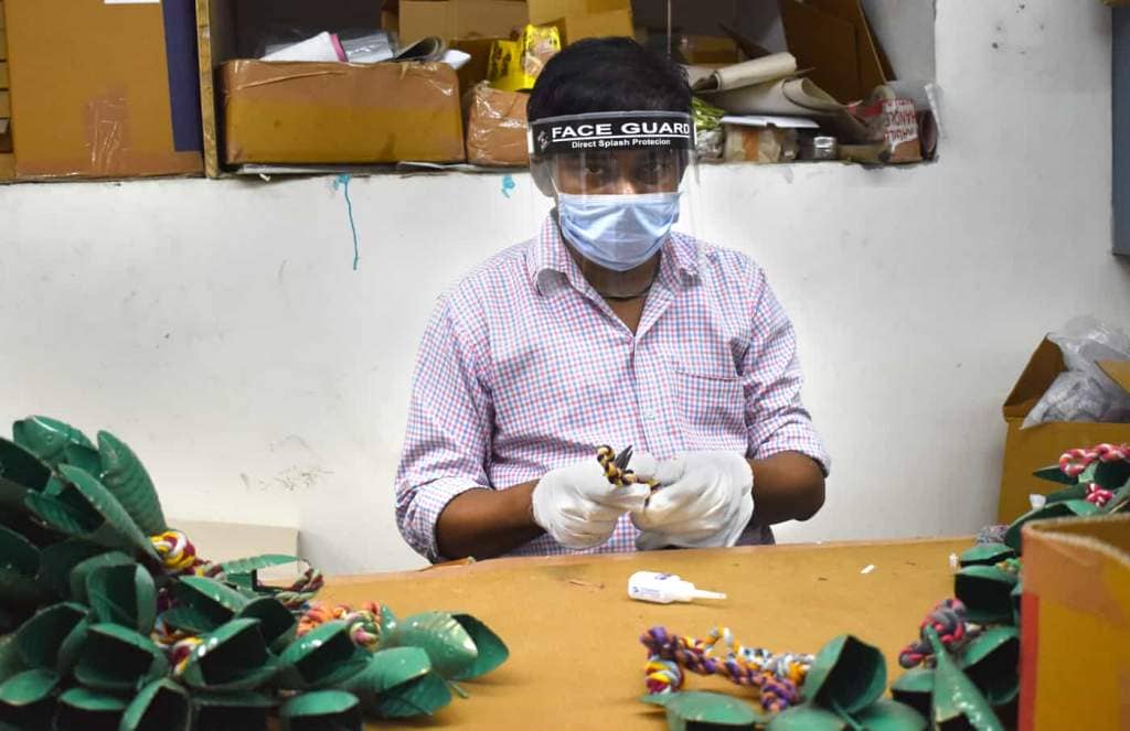 A masked worker faces the COVID challenge in a factory.