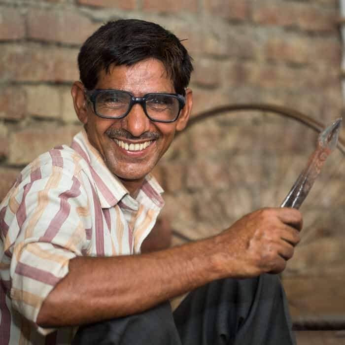 Dilshad Hussain is a man smiling while holding a knife.