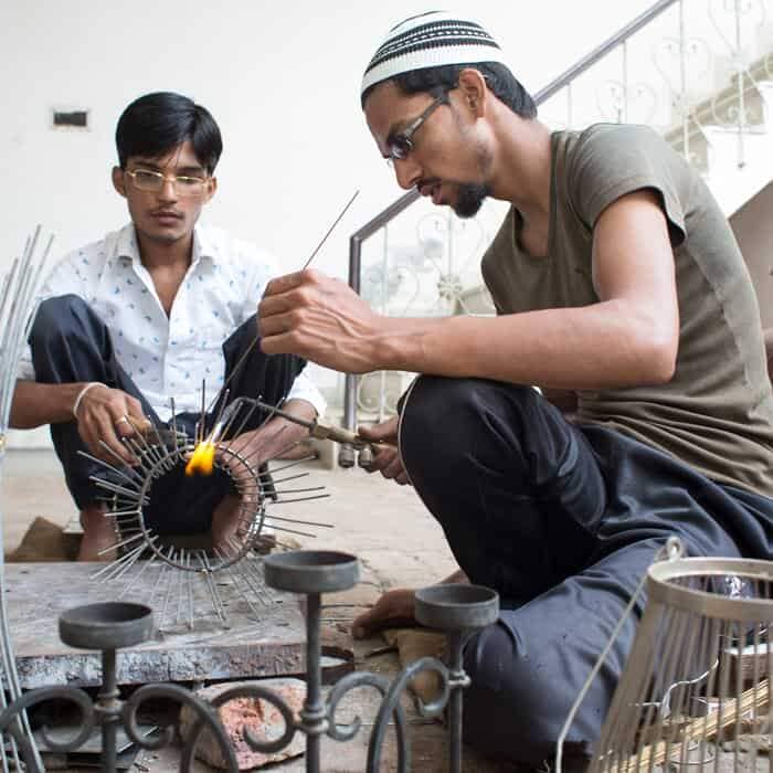 Two men, including Kamrul Hasan, working on a piece of metal. Two men, including Kamrul Hasan, working on a piece of metal.