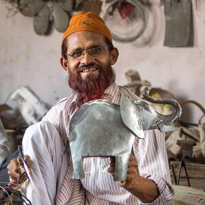 Khalil Ahmed holding up a metal elephant.