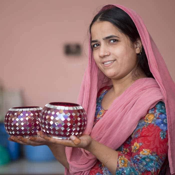 A woman in a sari holding two vases, captured by Mohammad Riyaz.